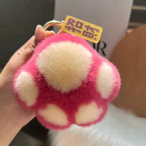 Nahaufnahme von pinkfarbenem und weißem Katzenpfoten-Plüsch-Schlüsselanhänger