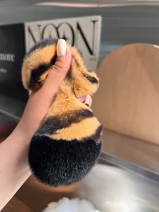Tiger pattern plush hair claw clip made of faux rabbit fur held in hand for size