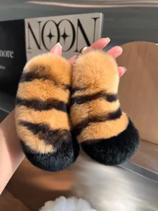 Close-up of fluffy tiger print charms with golden metal ring clasps and soft texture