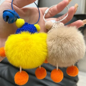 Cute fuzzy plush monster keychains with knit hats and bells in yellow and brown