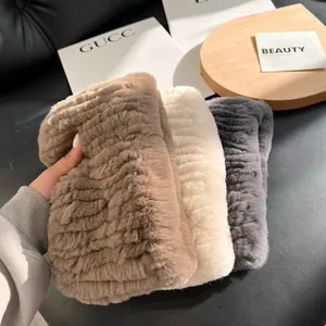 Close-up of thick rex rabbit fur scarves in khaki, white, and grey with soft striped texture