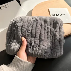 Detailed view of thick grey rabbit fur scarf showing soft fluffy texture and hand grip