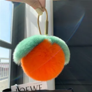 Detailansicht eines orangefarbenen Plüsch-Schlüsselanhängers mit grünen Blättern