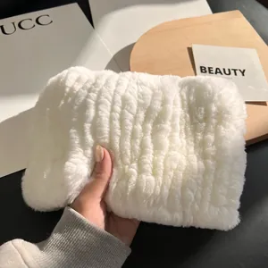 Close-up of a white faux fur pouch with elegant striped texture and soft plush feel