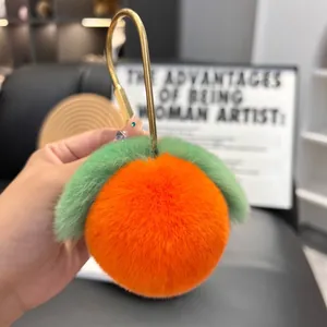 Detail of plush peach keychain showing soft faux fur texture and gold metal ring hook