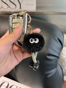 Dettaglio del portachiavi peluche nero con gambe lunghe intrecciate e chiusura