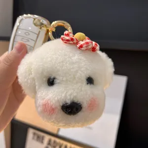 Détail d'un porte-clés chiot en peluche blanche avec un nœud à carreaux rouge et blanc