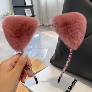 Detail van roze pluche kattenoren op een stijlvolle hoofdband met luipaardprint