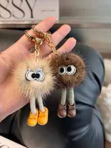Dettaglio ravvicinato dei portachiavi mostro di peluche con grandi occhi e scarpine