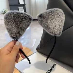 Detailopname van pluizige grijs-witte kunstbont kattenoren op een zwarte pluche haarband