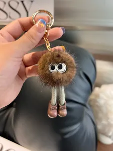 Dettaglio di un portachiavi di peluche marrone con grandi occhi e gancio dorato