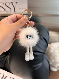 Primo piano di un portachiavi a sfera di peluche bianca con gambe lunghe su una rivista