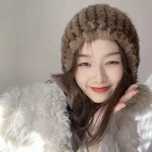 Close-up of brown mink fur knitted hat with soft texture on model in beige coat