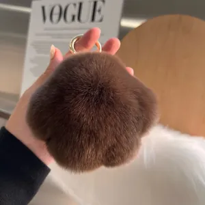Detail of star-shaped brown faux fur keychain with a gold ring held in hand