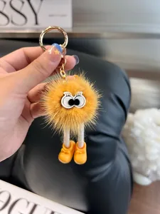Dettaglio del portachiavi a sfera di peluche giallo con gambe lunghe e occhi grandi
