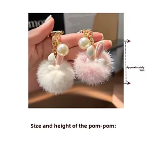 Close-up of 5cm plush bunny ear keychain with pearl detail and golden metal ring