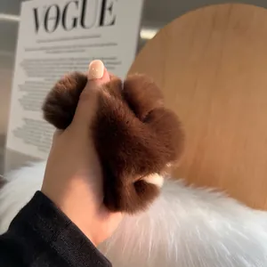 Deep brown fluffy rabbit fur elastic hair scrunchie shown in a stylish lifestyle setting