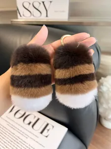 Detailed view of striped rabbit fur keychain with gold ring on fashion magazine
