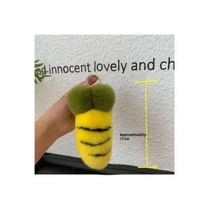 Detail of 17cm plush bee keychain charm featuring yellow faux fur and gold metal clasp