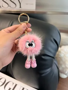 Dettaglio di un portachiavi in eco-pelliccia rosa con gambe lunghe e grandi occhi decorativi