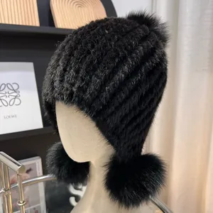 Detailed knit of black mink fur hat featuring three oversized fluffy fox fur pom-poms