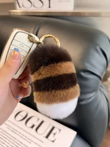Detailed close-up of a tricolor plush tail keychain with high-quality gold hardware