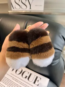 Close-up of fluffy rex rabbit fur paw keychain with gold metal ring and striped texture