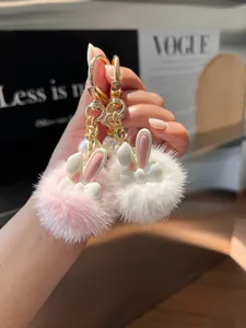Detail of pink and white plush bunny keychains with pearls and golden lobster clasp