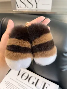 Detail of soft striped rabbit fur keychain with gold metallic ring on black leather