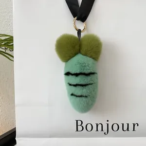 Detailed shot of soft plush carrot keychain with golden ring and black strap