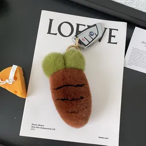 Close-up of a fluffy plush carrot keychain with a golden clasp on a branded magazine