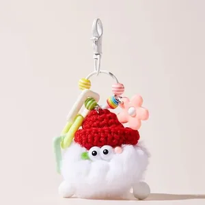 Dettaglio portachiavi in peluche con berretto rosso e perline colorate miste