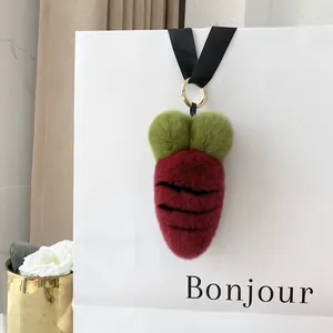 Detailed plush carrot keychain accessory hanging on a stylish white tote bag