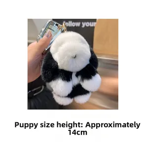 Détail d'un porte-clés chiot pelucheux noir et blanc de 14cm avec anneau doré