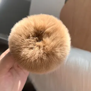 Dettaglio di un elastico per capelli in morbida pelliccia di coniglio color caramello