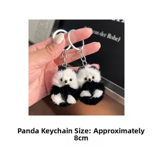 Détails de porte-clés panda en peluche de 8 cm tenus en main montrant la fourrure