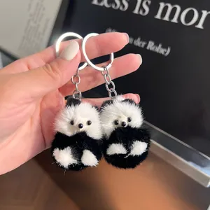 Détail de deux porte-clés panda en peluche noire et blanche avec des anneaux métalliques