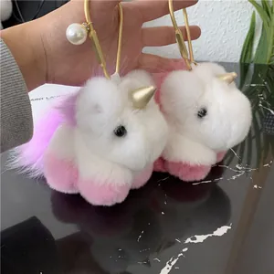 Detail of plush unicorn keychains featuring soft faux fur, gold horns and pearl accents