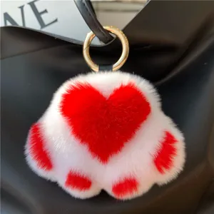 White faux fur cat paw keychain with red heart detail and gold ring accessory