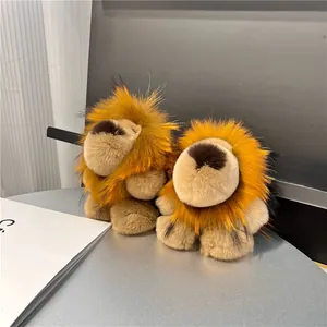 Porte-clés lion en fourrure de lapin avec crinières orange sur un bureau gris