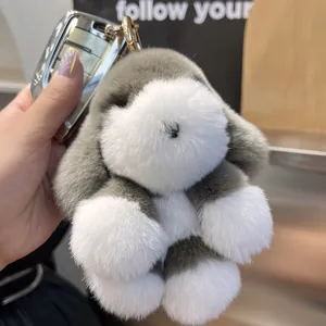 Gros plan du pendentif chiot en peluche gris et blanc avec fourrure et crochet doré
