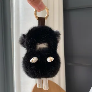 Detail showing the fluffy black faux mink fur lamb keychain and golden ring spring clip