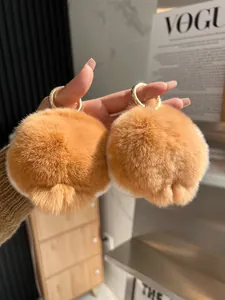 Dettaglio di ciondoli a forma di sedere di corgi in peluche con portachiavi dorati