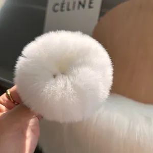 Dettaglio di un elastico per capelli bianco peloso con consistenza morbida e densa