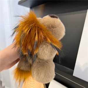 Gros plan sur le porte-clés lion en vraie fourrure de lapin avec une crinière orange douce