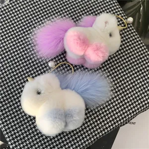Detail of plush unicorn keychain showing soft faux fur texture and golden metal clasp