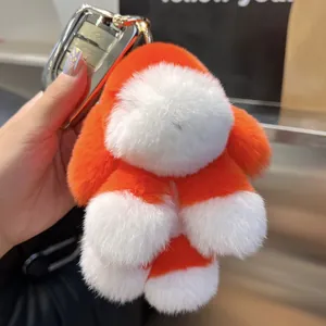Détail du porte-clés chiot en peluche orange et blanc avec attache métallique argentée