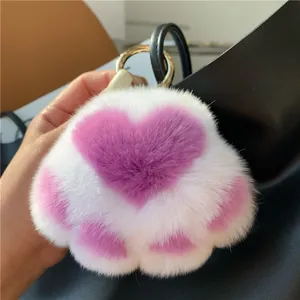 Plush cat paw keychain in white faux fur with pink heart design and gold ring