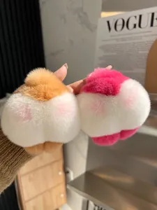 Dettaglio portachiavi peluche a forma di sedere di corgi in arancione e rosa su VOGUE