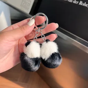 Détail d'un mignon porte-clés panda en peluche avec pompons doux et anneau métallique